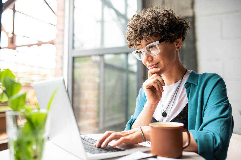 woman thinking and reading on laptop