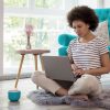 person sitting on floor with laptop in lap