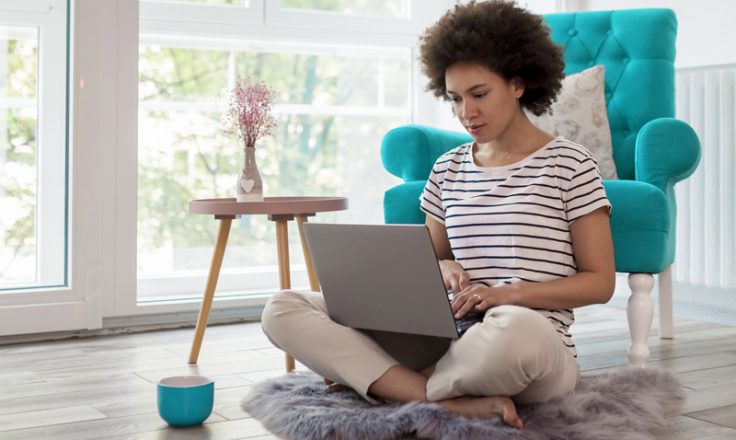 person sitting on floor with laptop in lap