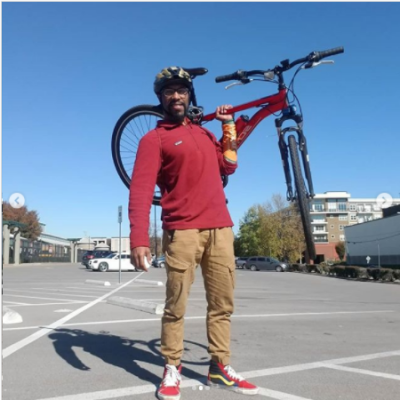 william wearing read shirt and helmet holding a bike