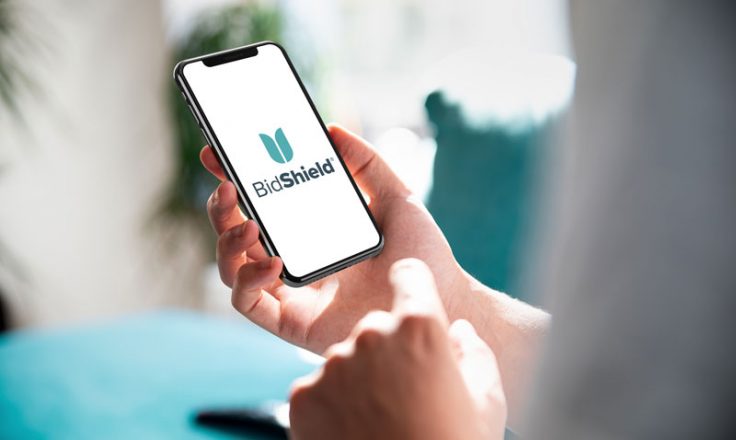bidshield logo on the phone being held