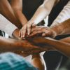 many people putting their hands together