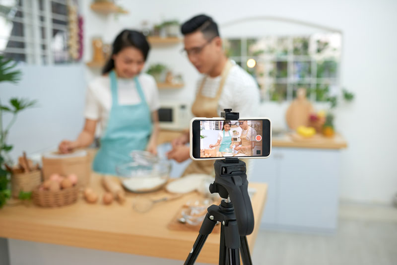 two people recording a cooking video