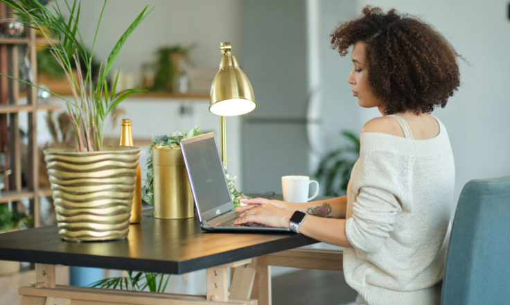 woman using computer at home desk