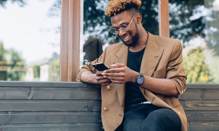 man sitting on a bench on his phone