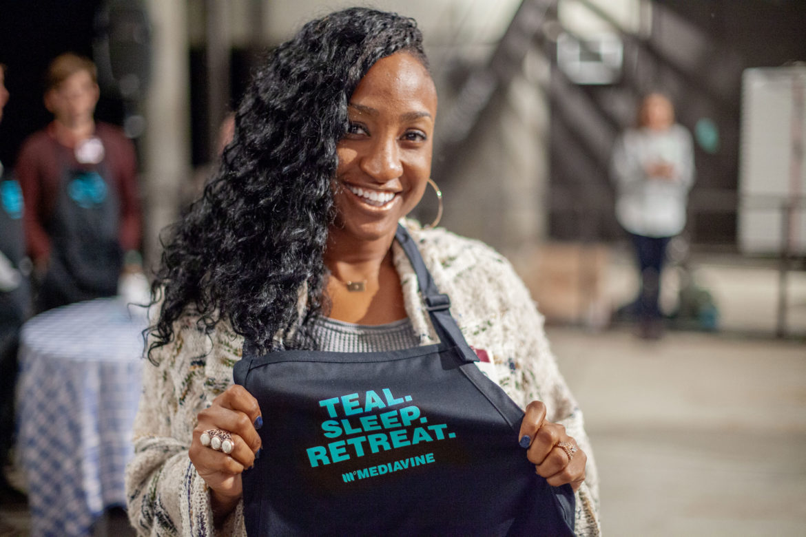 tq holding an apron that says 