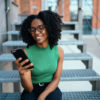 woman sitting on stairs looking at phone