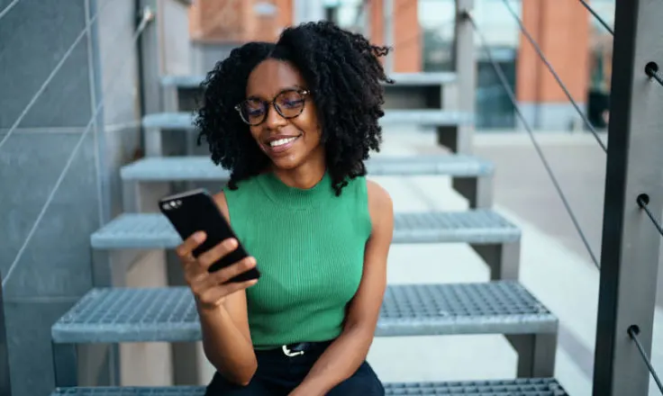 woman sitting on stairs looking at phone