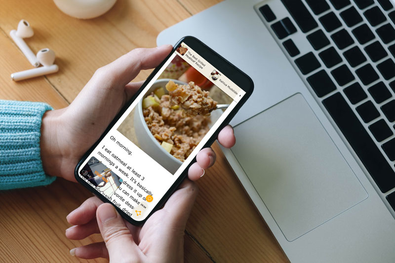 PERSON holding a phone at their desk