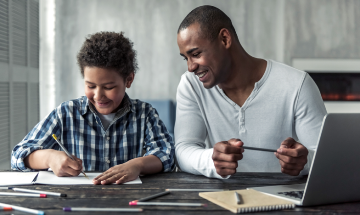 a young man helps a boy with a school project