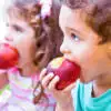 children biting into apples