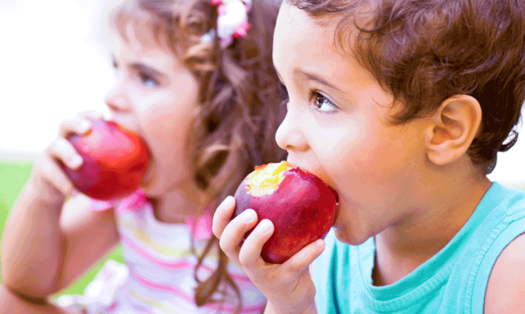 children biting into apples