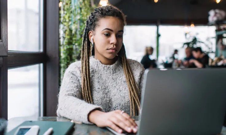 woman concentrating on her laptop in a workspace