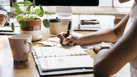 person using a planner at a desk