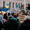 crowd holding flags and signs in support of ukraine